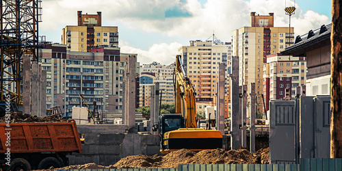 Yellow bulldozer working on urban construction site with concrete stilts photo