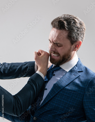 Professional man employee got punch in face with fist grey background, conflict