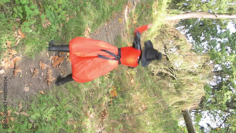 Beautiful girl dressed in a witch costume for Halloween. The witch is dancing. The child is dancing with autumn oak leaves. Vertical video. Beautiful girl dressed in a witch costume for Halloween. The witch is dancing. The child is dancing with autumn oak leaves. Vertical video.