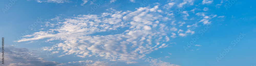 Panorama of blue sky with white air clouds. Banner.