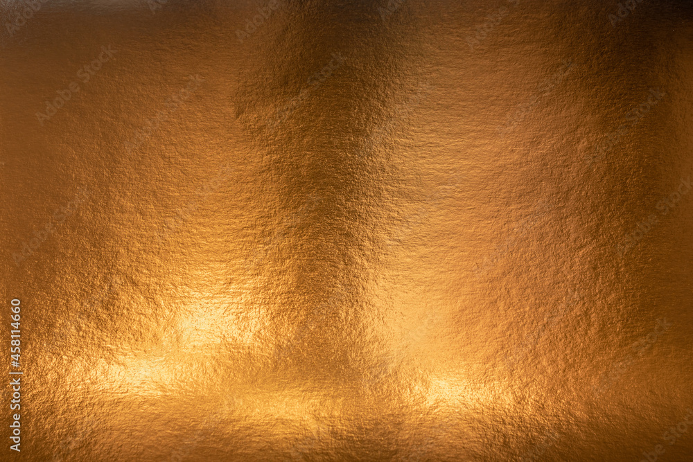 Textured metallic gold background with light and dark highlights, bright and shiny golden metal texture Textured metallic gold background with light and dark highlights, bright and shiny golden metal texture