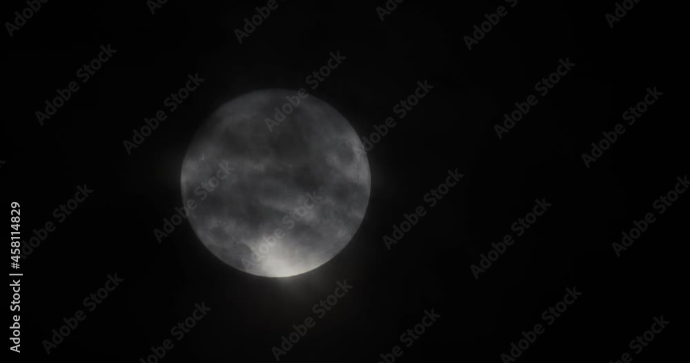 White full moon close up. The moon passing quickly through the clouds, the clouds blur the moon a little. White full moon close up. The moon passing quickly through the clouds, the clouds blur the moon a little.