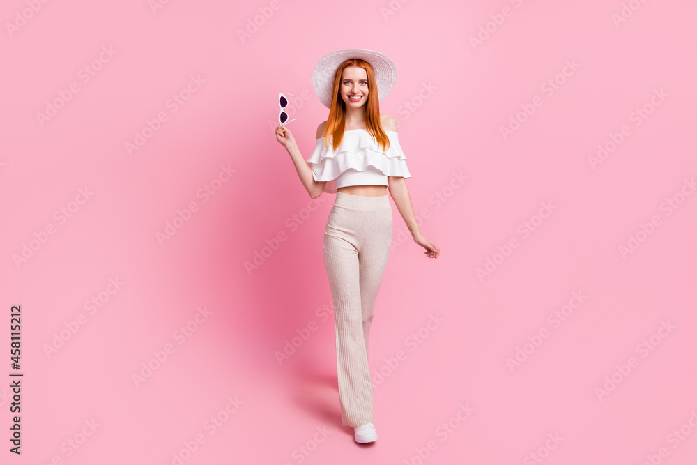 Full length body size view of attractive thin fashionable cheerful girl walking isolated over pink pastel color background
