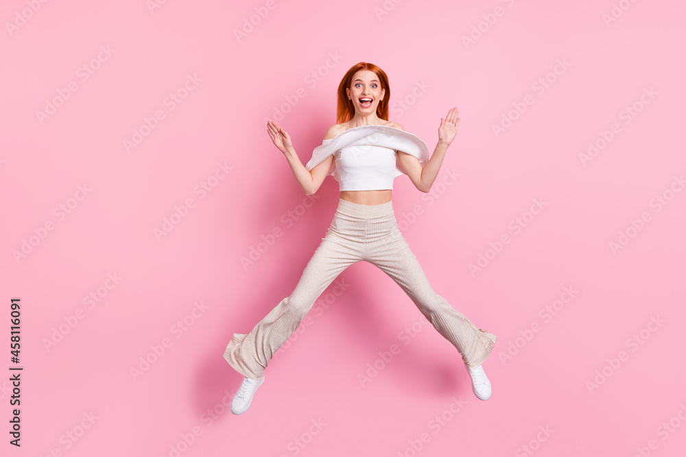 Full length body size view of attractive funky cheerful girl jumping having fun isolated over pink pastel color background