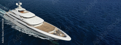Aerial drone ultra wide panoramic photo of beautiful modern super yacht with wooden deck cruising in high speed deep blue open ocean sea photo