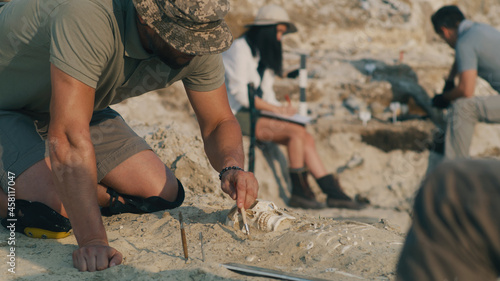 Male archaeologist working with human skeleton photo