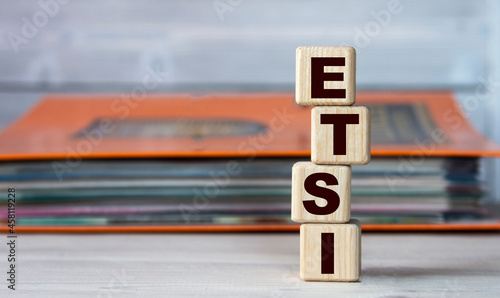 ETSI - word on wooden cubes on the background of a folder with documents photo
