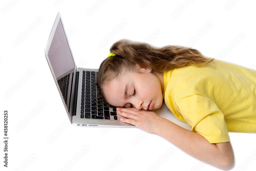 The little girl in the yellow T-shirt got tired and fell asleep at the laptop. The concept of distance learning during COVID-19. The little girl in the yellow T-shirt got tired and fell asleep at the laptop. The concept of distance learning during COVID-19.