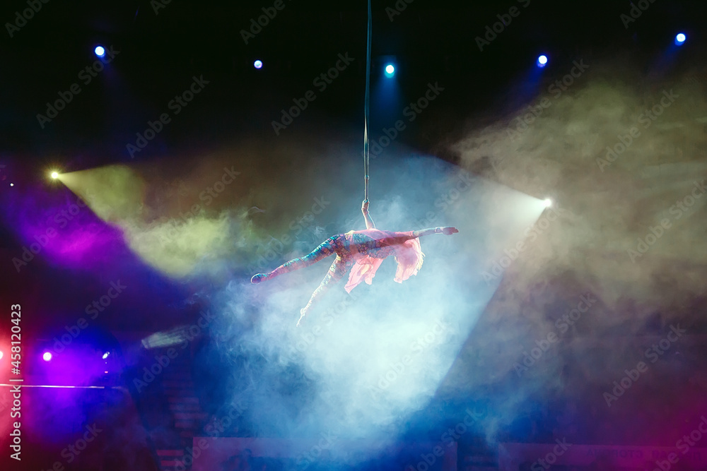 Fototapeta premium An aerial gymnast shows a performance in the circus arena.