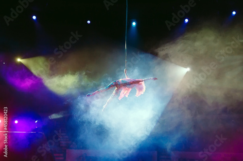 An aerial gymnast shows a performance in the circus arena. photo