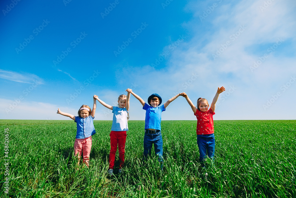 Happy Children on a green field with their hands up. Happy Children on a green field with their hands up.