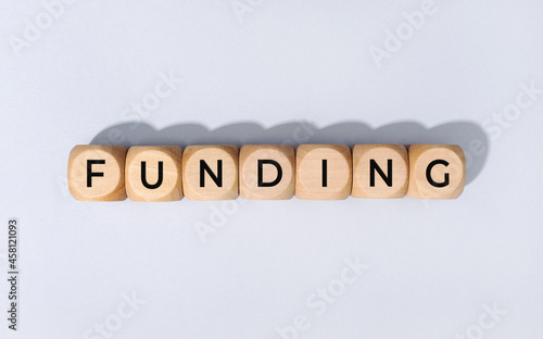 Funding word on wooden block isolated on gray background