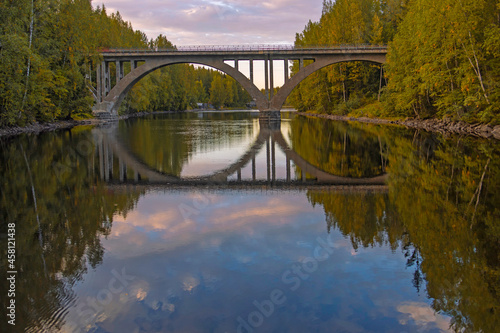 Finnish arched bridge with a narrow gauge railway, built in the early twentieth century, across the Yanisyoki River, Karelia, Russia. Autumn, september