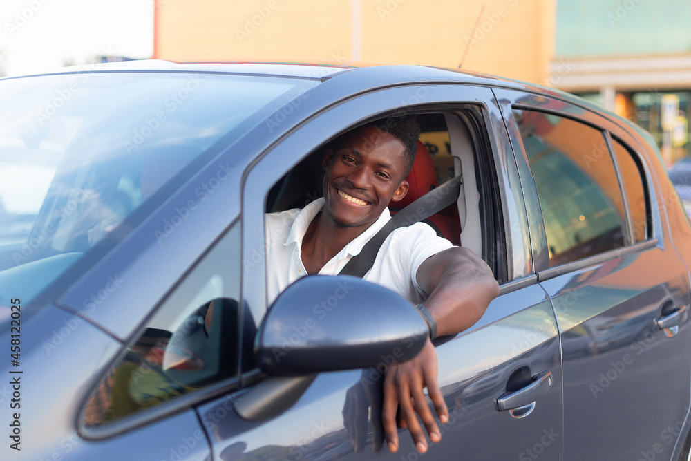 A happy African-American man is sitting in the car. Human emotions