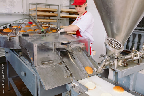 Fotografie Conveyor belt in a bakery with newly baked buns.
