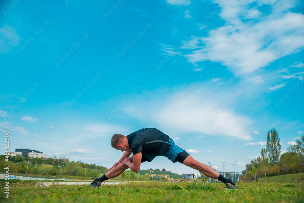 Young strong male jogger working out outdoors in summer sunny day Young strong male jogger working out outdoors in summer sunny day