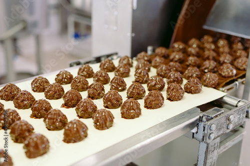 Canvas Print sweets production and industry concept - chocolate candies processing on conveyor at confectionery shop