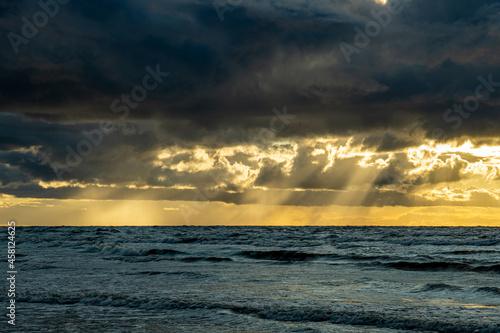 golden sunset in Baltic Sea in the fall with rain clouds