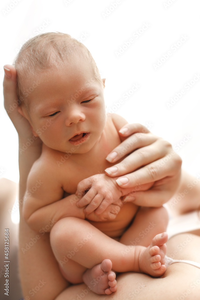 Sleeping newborn baby on the hands of mother. A few days from birth. White background. Mom kissing her son. Sleeping newborn baby on the hands of mother. A few days from birth. White background. Mom kissing her son.