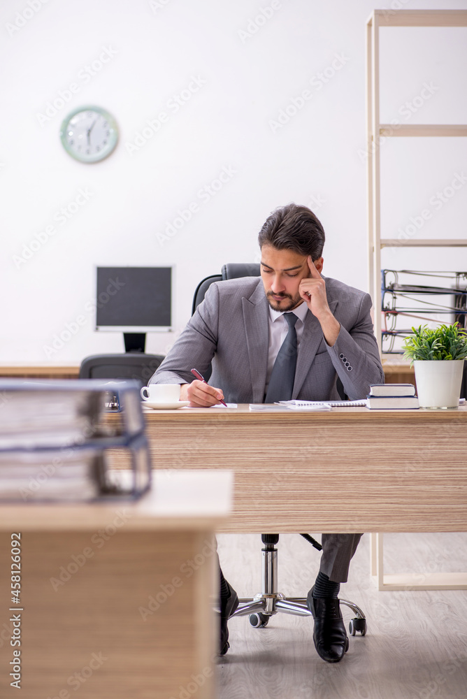 Young male employee working in the office Young male employee working in the office
