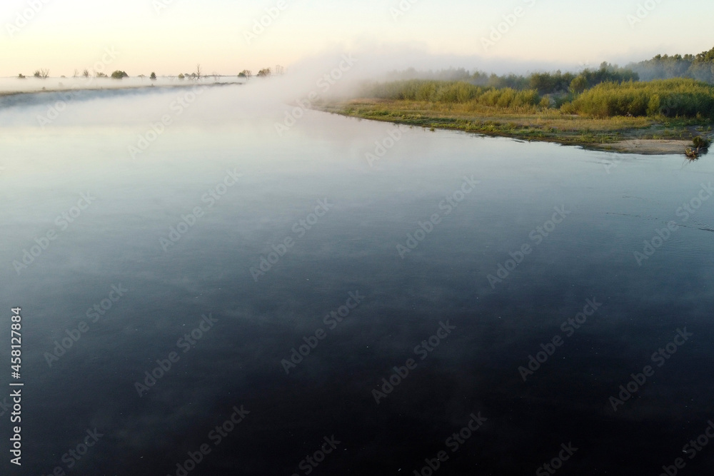 Mist covers the river, trees, and land at dawn. Autumn photos of fog taken with drone Mist covers the river, trees, and land at dawn. Autumn photos of fog taken with drone