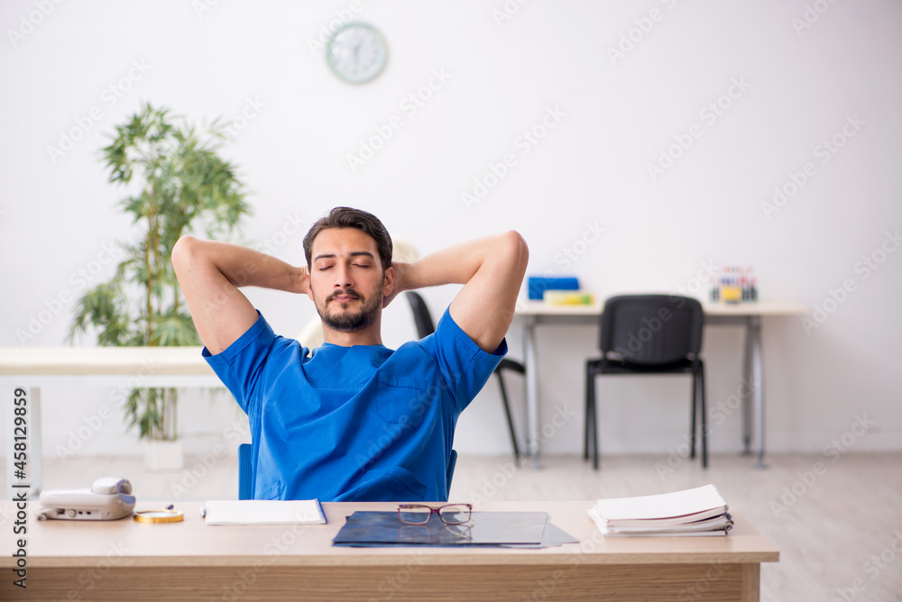 Young male doctor sitting in the clinic Young male doctor sitting in the clinic
