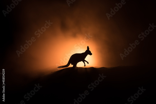 Kangaroo miniature standing at foggy night. Creative table decoration with colorful backlight with fog.