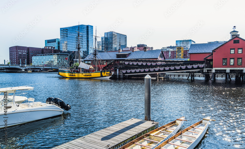 Boston city seascape with moored boats and canoes with the view of Boston Tea Party Ship at Fort Point Channel