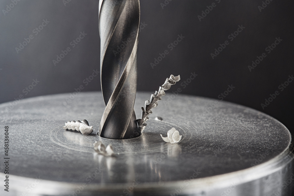 metal drill bit make holes in steel billet on industrial drilling machine. Metal work industry. multi cutting tool and end mill. - obrazy, fototapety, plakaty 