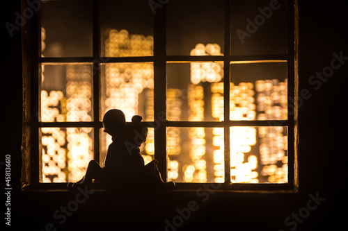 A realistic dollhouse living room with furniture and window at night. Romantic couple sitting on window. Artwork table decoration with handmade realistic dollhouse. Selective focus.