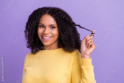 Photo of pretty flirty dark skin girl dressed yellow sweatshirt finger curl smiling isolated purple color background