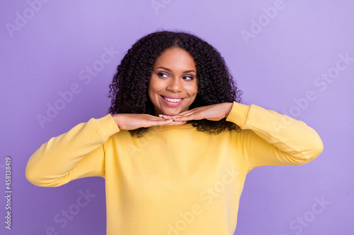 Photo of thoughtful pretty dark skin girl dressed yellow sweatshirt arms chin looking empty space isolated purple color background © deagreez