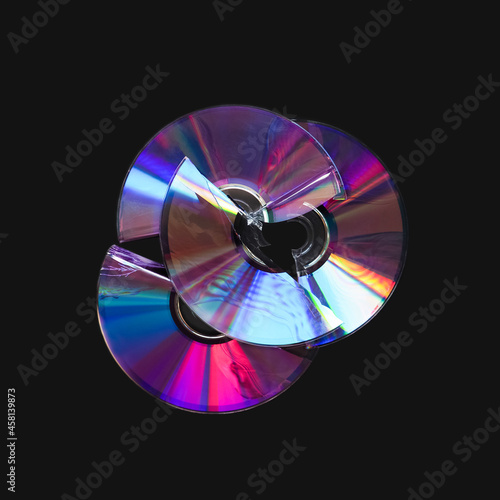 Two broken CD and DVD discs isolated on black background. Damaged CD, DVD compact discs. Data destruction