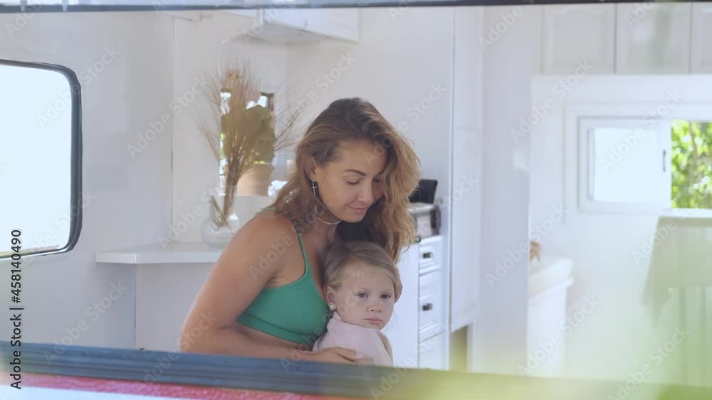 view in the camper window, mom hugs and kisses daughter view in the camper window, mom hugs and kisses daughter