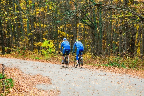 Men biking down road in the fall