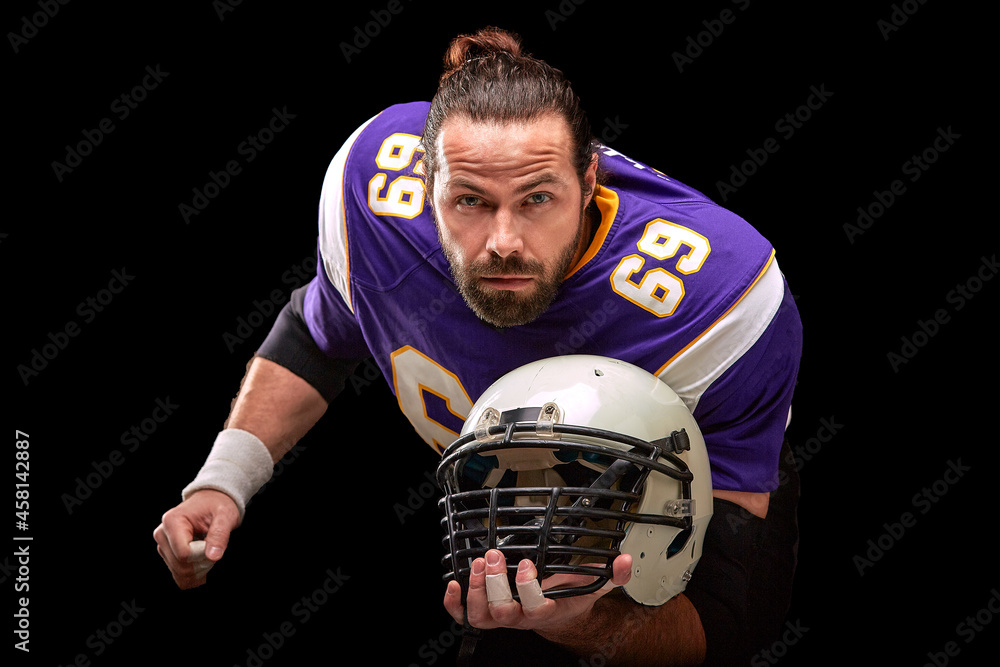 Fototapeta premium Portrait of american football player with helmet in hand close up