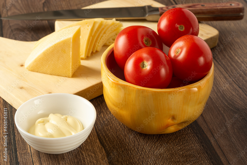 Perfect cherry tomatoes, cheese slices and sauce on the table Perfect cherry tomatoes, cheese slices and sauce on the table
