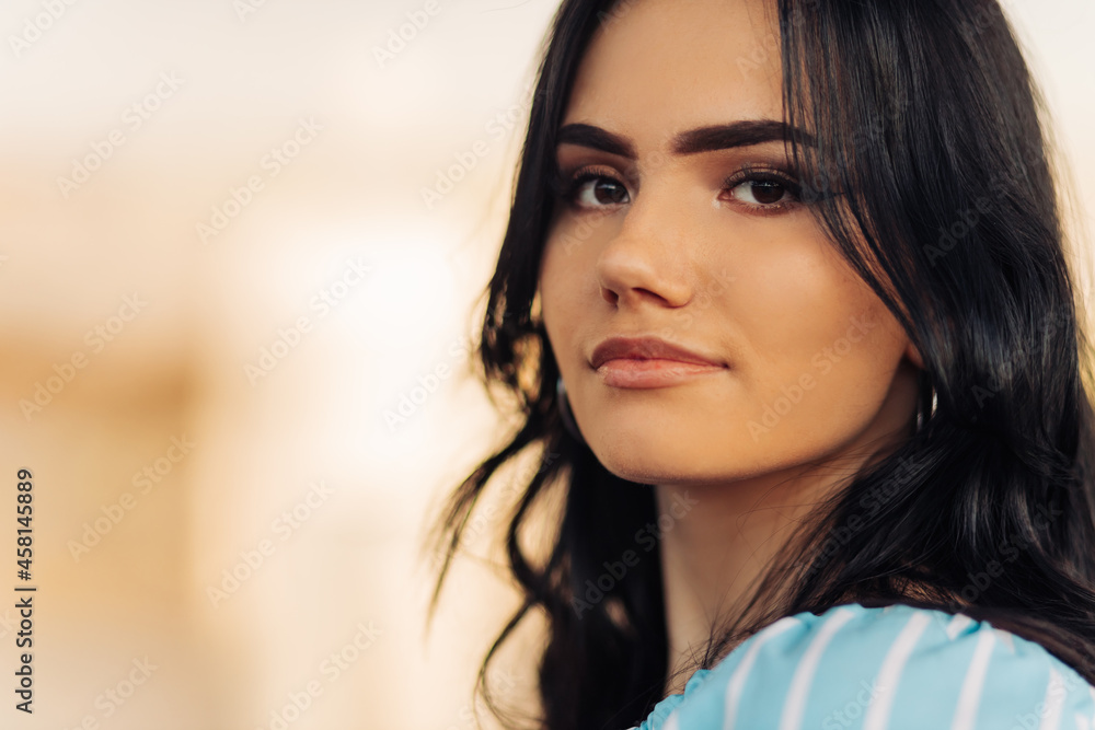 attractive young woman smiling and looking at camera while standing on the street attractive young woman smiling and looking at camera while standing on the street