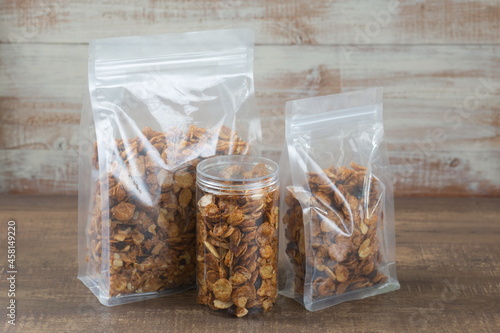 Caramel cornflakes in plastic bag package on wooden table.