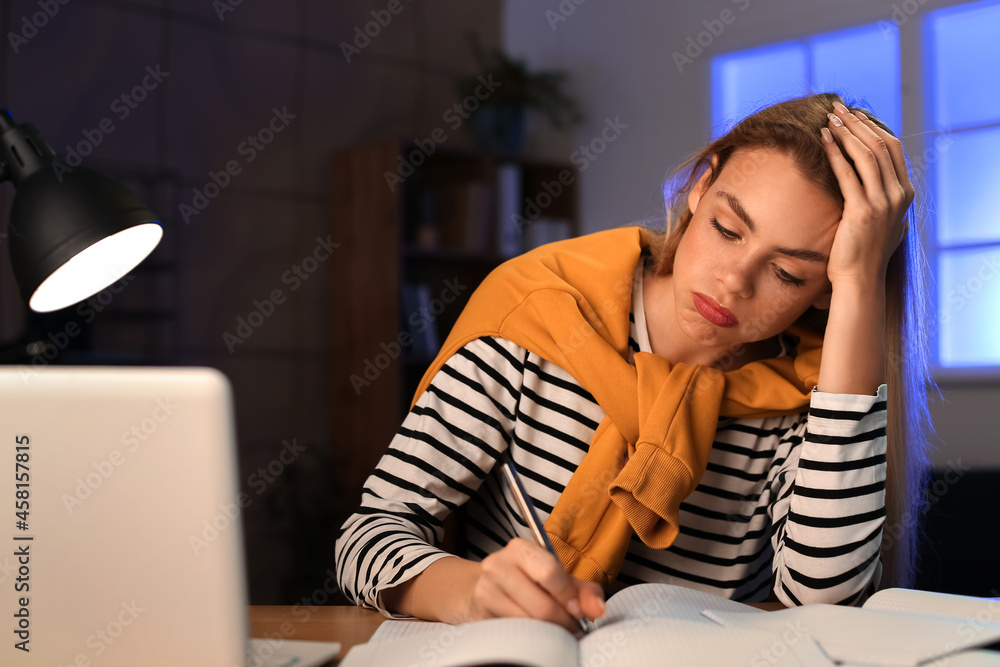 Female student preparing for exam at home late in evening Female student preparing for exam at home late in evening