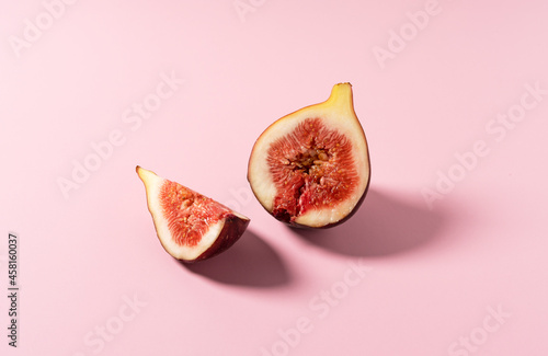 Cut figs placed on a pink background.