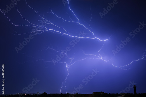 Dark sky with lightning over night city