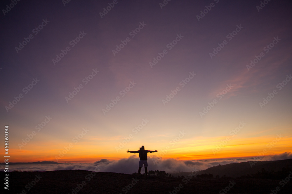 silhouette of a cross in the mountains