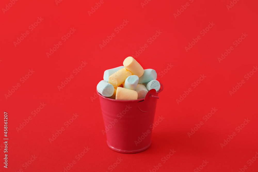 Bucket with marshmallows on red background Bucket with marshmallows on red background