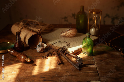 On the old table are: an old book, manuscripts, bottles for potions and poisons, a seashell, a magnifying glass in a brass frame, an old pince-nez, rusty keys to chests, a sea rope.