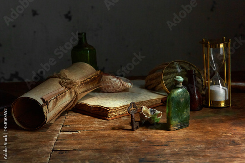 Medicines and substances in glass bottles on an old wooden table. A medieval scientist's room with various flasks and old books