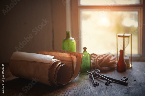 On the old table are: an old book, manuscripts, bottles for potions and poisons, a seashell, a magnifying glass in a brass frame, an old pince-nez, rusty keys to chests, a sea rope.