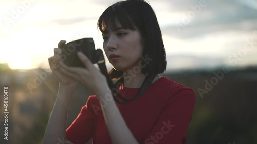 街を散策しながらカメラで撮影する女性