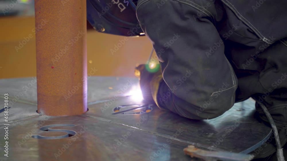 Cropped View Of A Male Welder In Protective Gear Welding Metal Table. close up