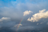 Sky with clouds and a rainbow particle